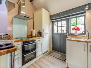 a kitchen with white cabinets and a sink at Stable Cottage in Pembroke