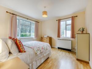 a bedroom with a bed and two windows at Pine Cottage - Uk46874 in Hartland