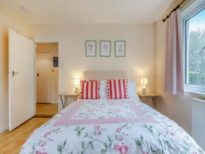 a bedroom with a large bed with red pillows at Pine Cottage - Uk46874 in Hartland