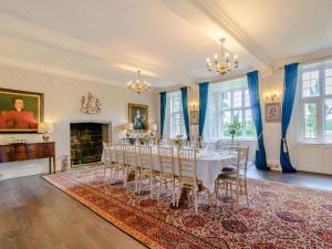 a room with a table with chairs and a fireplace at Hodroyd Hall in Holmfirth