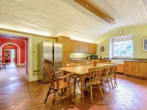 a kitchen with a table and chairs and a refrigerator at Hodroyd Hall in Holmfirth