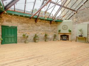 a large room with a green door and a brick wall at Hodroyd Hall in Holmfirth +13 photos