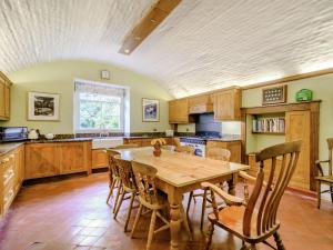 a large kitchen with a wooden table and chairs at Hodroyd Hall in Holmfirth