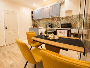 a kitchen with a table and some yellow chairs at NDK - Dream House in Sofia