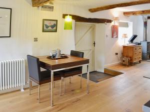 a dining room with a wooden table and chairs at Granny Mcphees Cottage Hssh in Beaworthy