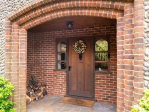a brick entry way with a wooden door with a wreath at Cranny Hill in Walpole