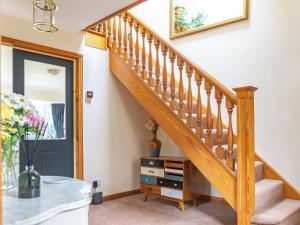 a staircase in a house with a table and a mirror at Cranny Hill in Walpole +25 photos
