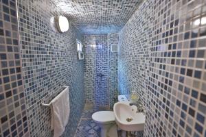a blue tiled bathroom with a toilet and a sink at Riad Medina Unique in Fez +35 photos