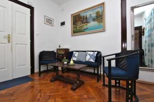 a living room with chairs and a table and a painting at Guest House Barocco in Rovinj