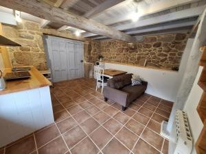 a kitchen and living room with a couch and a table at Casa de mestre 2 in Freijo