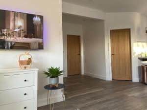 a living room with a dresser and a potted plant at Blue Heron Lodge in Brough