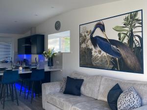 a living room with a bird painting on the wall at Blue Heron Lodge in Brough +27 photos