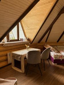 a room with a table and two chairs in a attic at Lavender House in Slavske