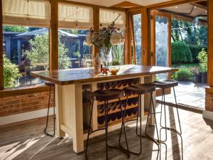 a kitchen with a island with bar stools at Myrtle Cottage in Potter Heigham