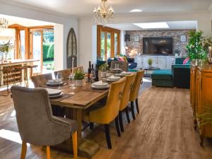 a dining room and living room with a table and chairs at Myrtle Cottage in Potter Heigham
