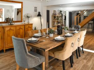 a dining room with a wooden table and chairs at Myrtle Cottage in Potter Heigham
