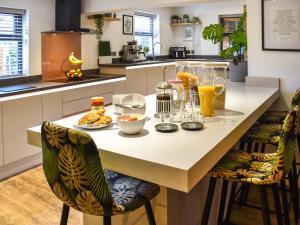 a kitchen with a table with food and drinks on it at Myrtle Cottage in Potter Heigham +34 photos