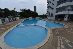 a large blue swimming pool next to a building at Rayong Condochain 325 in Ban Pak Khlong Phe