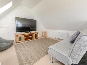 a living room with a flat screen tv and a couch at Lower Hendra Cottage in Port Isaac