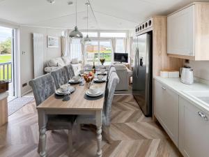 a kitchen and dining room with a table and chairs at Reel Paradise - Uk37723 in Ingoldmells