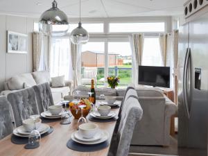a kitchen and living room with a table and a refrigerator at Reel Paradise - Uk37723 in Ingoldmells