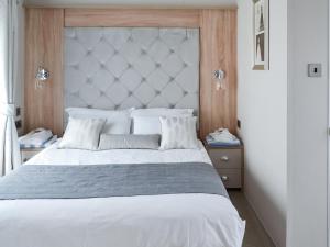 a bedroom with a large bed with a large headboard at Reel Paradise - Uk37723 in Ingoldmells