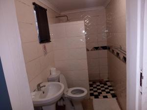 a small bathroom with a toilet and a sink at Lancaster Guest House in Boksburg +122 photos