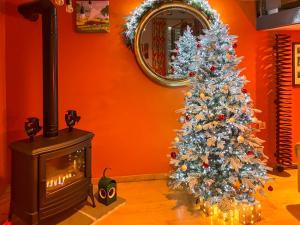 ein Weihnachtsbaum in einem Wohnzimmer mit Kamin in der Unterkunft The Engine Room in Malham