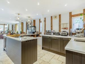 a large kitchen with brown cabinets and a counter top at Granary Barn in Ashwellthorpe