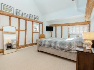 a bedroom with a bed and a mirror at Granary Barn in Ashwellthorpe +17 photos