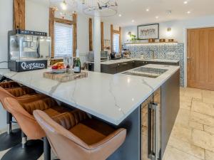 a kitchen with a large island with bar stools at Granary Barn in Ashwellthorpe