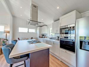 a kitchen with white cabinets and a counter top at Glencoe Luxury Lodge in Erskine