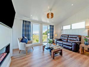 a living room with a couch and a table at Glencoe Luxury Lodge in Erskine