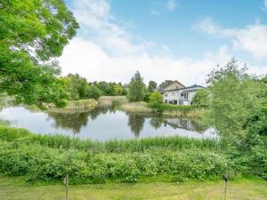a house and a pond in front of a house at Plovers Nest At Lower Mill in Somerford Keynes