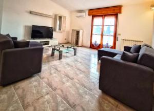 a living room with couches and a flat screen tv at Big Apartment in Assemini