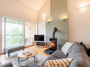a living room with a couch and a fireplace at Plovers Nest At Lower Mill in Somerford Keynes +25 photos
