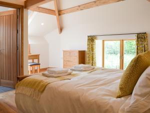 a bedroom with a large bed with towels on it at The Horse Gin - Uk11024 in East Worlington +14 photos