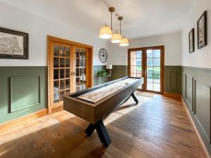 a pool table in the middle of a room at Pant Ifan Goch in St Asaph
