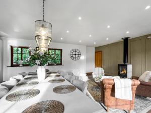 a dining room with a table and a fireplace at Pant Ifan Goch in St Asaph