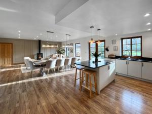 an open kitchen and living room with a table and chairs at Pant Ifan Goch in St Asaph +24 photos