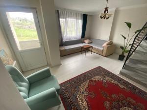 a living room with a couch and a window at Daily airport aparthotel in Taşoluk