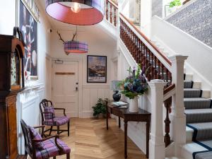 a hallway with stairs and a table and chairs at Croft House - Uk7555 in Inverness