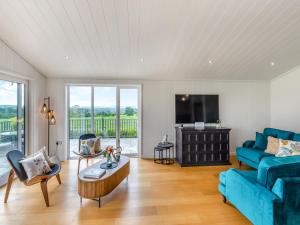 a living room with a blue couch and a tv at Whitehill Lodge - Uk47194 in Kirkcambeck