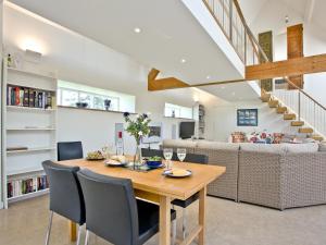 a dining room and living room with a table and chairs at Antells Farm Barn in Sturminster Newton
