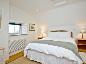 a bedroom with a large white bed and two lamps at Antells Farm Barn in Sturminster Newton +19 photos