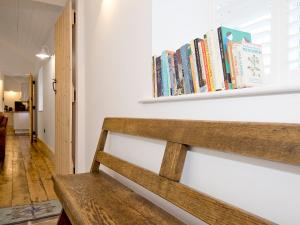 a wooden bench with books on a wall at Ty Cai in Llanwnda