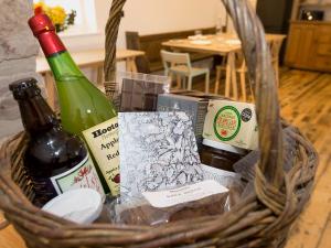 a basket with a bottle of wine and cheese at Ty Cai in Llanwnda