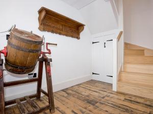 a room with a barrel on a stand next to a door at Ty Cai in Llanwnda +12 photos