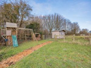 a farm with a playground and a wooden fence at Amaranth in Shurdington
