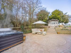 a patio with a grill and an umbrella and a house at Amaranth in Shurdington +17 photos